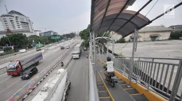 Pengendara sepeda motor melintasi JPO di Jalan Yos Sudarso, Jakarta, Senin (12/11). Aksi nekat yang dilakukan para pengendara sepeda motor demi mempersingkat rute jalan tersebut sangat mengganggu kenyamanan pejalan kaki. (Merdeka.com/Iqbal S. Nugroho)