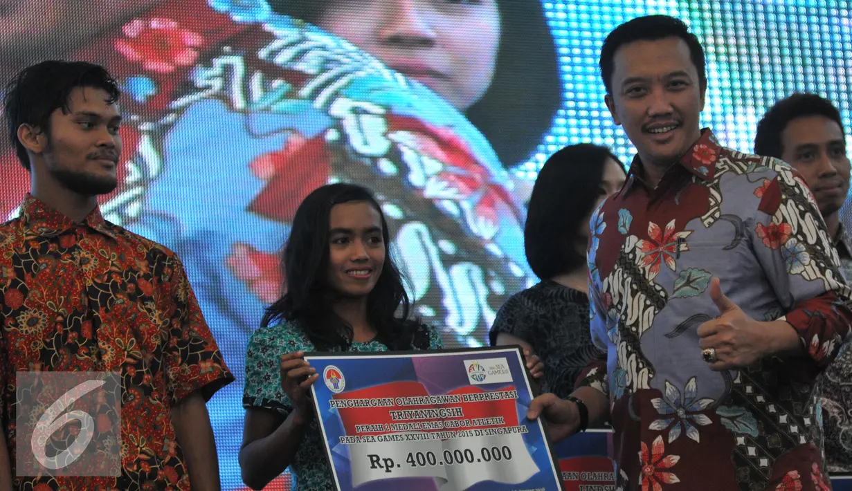 Menpora Imam Nahrawi menyerahkan penghargaan pada atlit cabang atletik, Trianingsih yang berhasil meraih dua Emas di Sea Games ke-28 Singapura 2015, di Gedung Kemenpora, Jakarta, Kamis (9/7/2015). (Liputan6.com/Herman Zakharia)