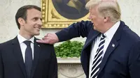 Donald Trump Membersihkan Ketombe di Bahu Presiden Emmanuel Macron (Brendan Smialowski / AFP)