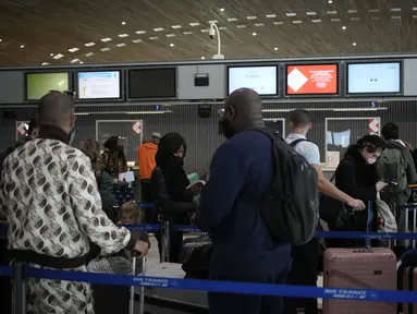 Pelancong ke Amerika Serikat menunggu di meja check-in di bandara Charles de Gaulle, utara Paris, Senin (8/11/2021).  AS pada Senin mencabut pembatasan perjalanan dari daftar panjang negara termasuk Meksiko, Kanada, dan sebagian besar Eropa. (AP Photo/Christophe Ena)