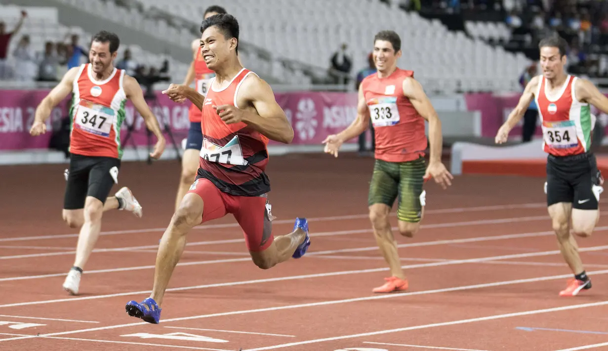 Purnomo Sapto Yogo pelari Indonesia meraih medali emas di nomor 100 meter putra klasifikasi T37 pada Asian Para Games 2018, di Stadion Utama Gelora Bung Karno Jakarta, Selasa (9/10/2018).  (Bola.com/Peksi Cahyo)