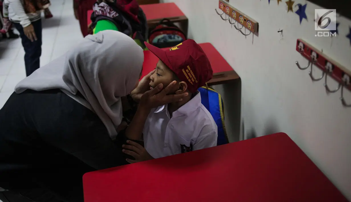 Seorang ibu mendampingi anaknya saat hari pertama masuk sekolah di SDN Pisangan 02, Ciputat, Tangerang Selatan, Senin (15/7/2019). Senin, 15 Juli 2019 merupakan hari pertama masuk sekolah tahun ajaran 2019/2020 usai libur panjang. (Liputan6.com/Faizal Fanani)