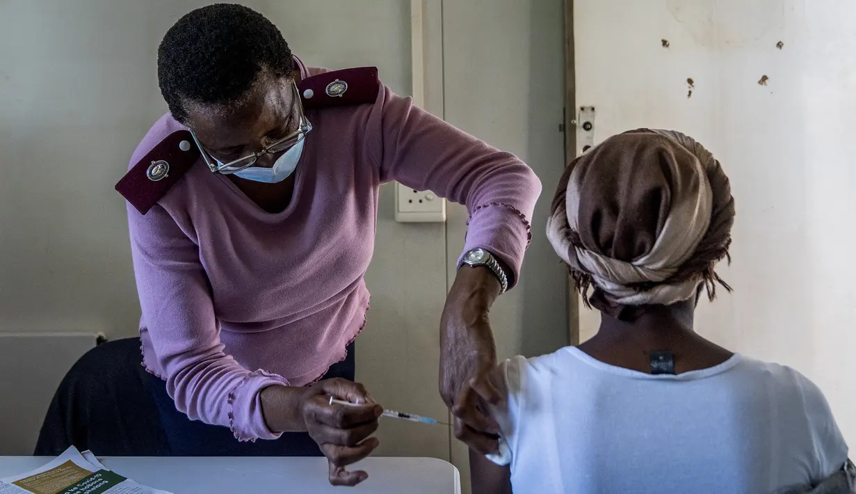 Seorang perempuan divaksinasi COVID-19 di Lawley, selatan Johannesburg, Afrika Selatan, Rabu (1/12/2021). Para ilmuwan mengatakan perlu waktu berminggu-minggu sebelum mereka lebih memahami betapa berbahayanya varian baru omicron. (AP Photo/ Shiraaz Mohamed)