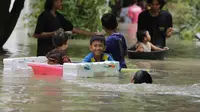 Anak-anak korban banjir tampak asyik bermain air bersama teman sebaya mereka. (Liputan6.com / Panji Prayitno)