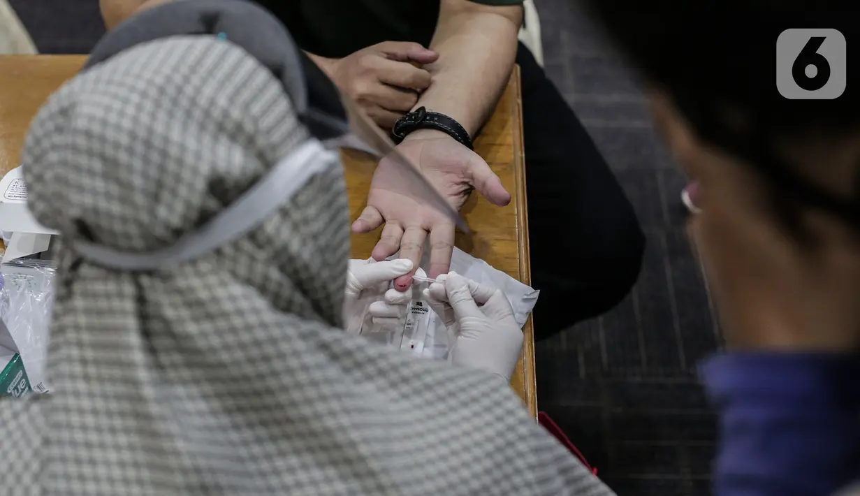 Petugas medis mengambil sampel darah wartawan yang bertugas di DPR saat rapid test di Ruang Wartawan, Kompleks Parlemen, Senayan, Jakarta, Rabu (1/7/2020). Rapid test yang digelar secara gratis ini untuk mendeteksi penyebaran dan memutus mata rantai Penyebaran Covid 19. (Liputan6.com/Johan Tallo)