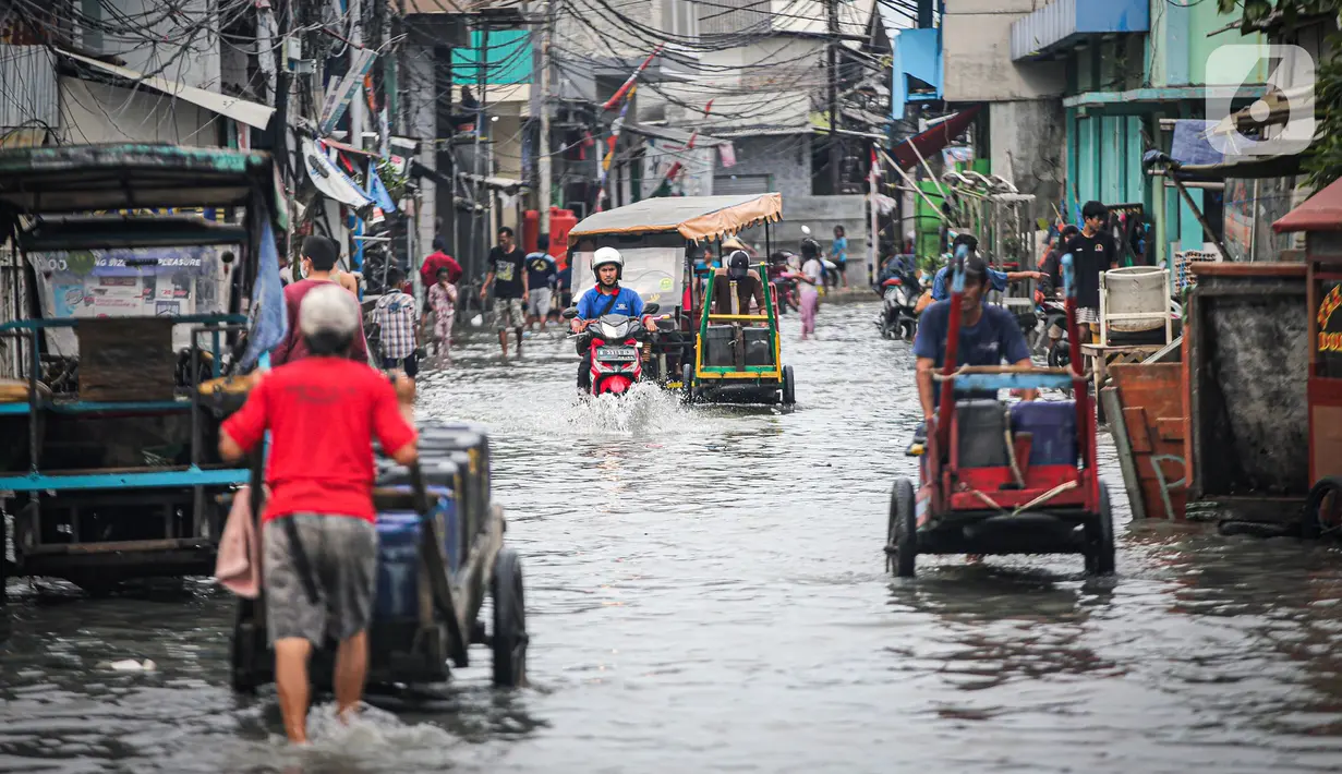 Warga beraktivitas saat banjir rob di Muara Angke, Jakarta, Jumat (25/11/2022). Badan Penanggulangan Bencana Daerah (BPBD) DKI Jakarta mengimbau agar warga di pesisir Jakarta mengantisipasi banjir pesisir atau rob selama 22-28 November 2022. (Liputan6.com/Faizal Fanani)