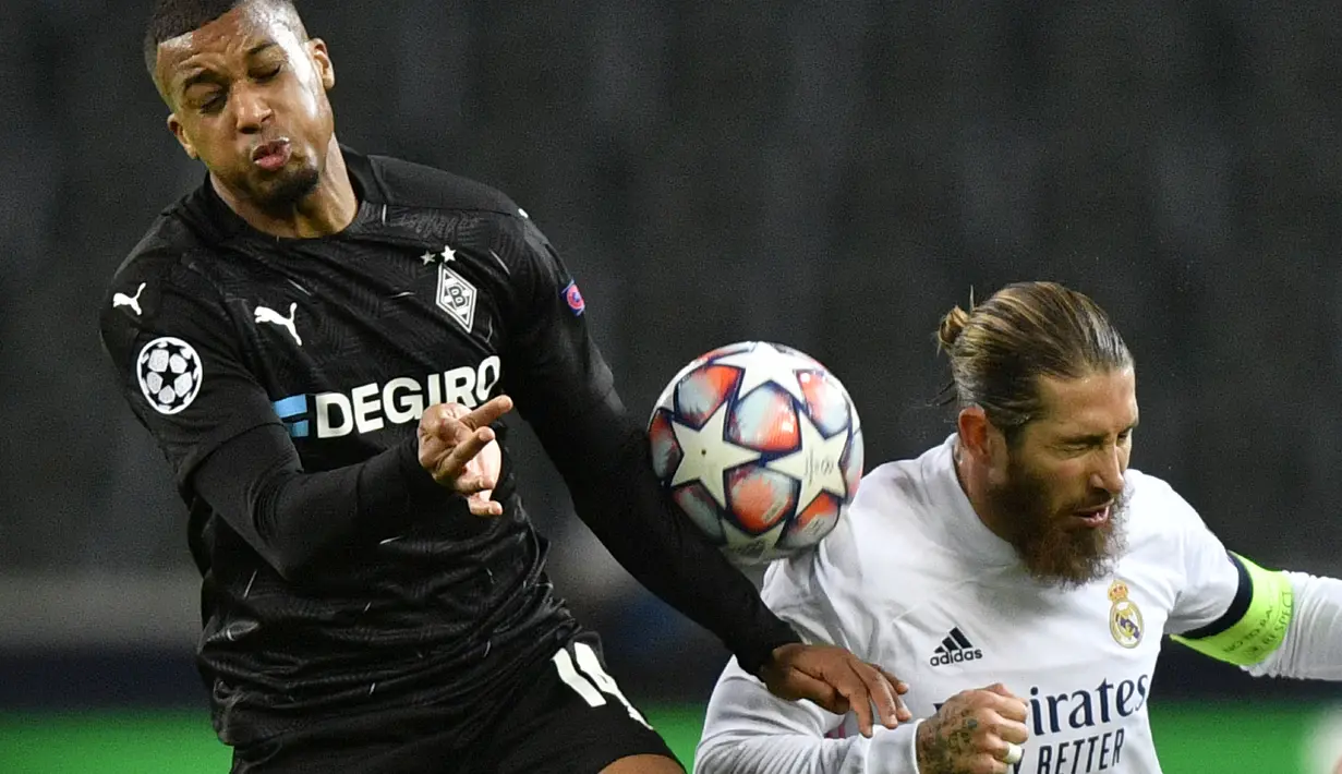 Bek Real Madrid, Sergio Ramos berebut bola dengan pemain Borussia Monchengladbach, Alassane Plea pada pertandingan grup B Liga Champions di  Borussia Park, Jerman, Selasa (27/10/2020). Madrid bermain imbang 2-2 atas Monchengladbach. (AP Photo/Martin Meissner)