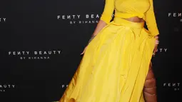 Rihanna berpose untuk fotografer setibanya pada peluncuran Fenty Beauty by Rihanna di Duggal Greenhouse, New York, Kamis (7/9). Rihanna tampil balutan kaus kuning yang dipadukan dengan rok berwarna senada. (Victor Malafronte/STAR MAX/IPx/AP Images)