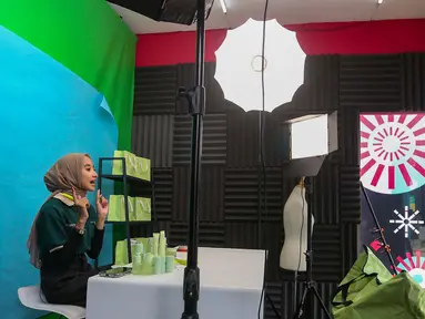 Afiliator saat menawarkan produk secara daring atau online dengan melakukan siaran langsung melalui aplikasi di dalam kotak studio siaran saat Hari Belanja Online Nasional (Harbolnas) 1212 di Jakarta, Kamis (12/12/2024). (Liputan6.com/Angga Yuniar)