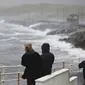 Warga melihat gelombang tinggi di pesisir Irlandia yang disebabkan oleh terjangan Badai Ophelia. (Niall Carson/PA via AP)