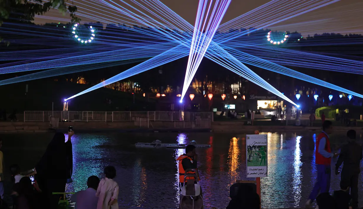 Warga menghadiri festival cahaya Noor Riyadh yang diadakan di Taman Al-Salam, Riyadh, Arab Saudi, 3 November 2022. Lebih dari 190 karya seni dipamerkan di ruang publik Riyadh selama festival cahaya Noor Riyadh, termasuk instalasi monumental dan interaktif serta patung-patung. (Fayez Nureldine/AFP)