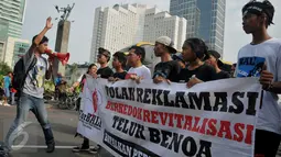 Sejumlah aktivis 'For Bali' menggelar aksi damai saat kegiatan Car Free Day (CFD) di Bundaran HI, Jakarta, Minggu (10/4). Mereka menolak rencana reklamasi Teluk Benoa menyusul adanya wacana proyek tersebut akan berjalan terus (Liputan6.com/Gempur M Surya)