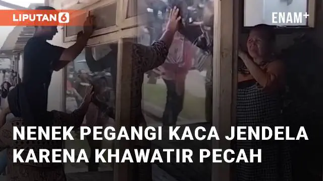 Nenek dibantu warga sekitar menahan kaca jendela rumahnya yang bergetar. Kaca ditahan agar tidak pecah saat truk sound horeg melintas