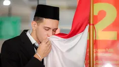 Pemain naturalisasi Indonesia, Justin Hubner mencium bendera merah putih setelah pengambilan sumpah WNI yang berlangsung di Kantor Wilayah Kementerian Hukum dan HAM (Kanwil Kemenkumham), Jakarta Timur, Rabu (06/12/2023). (Bola.com/Bagaskara Lazuardi)