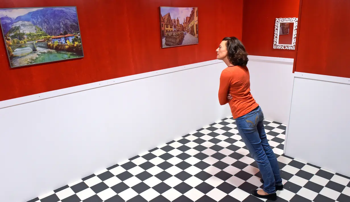 Pengunjung berdiri di ruangan yang menimbulkan ilusi miring dalam pameran bertajuk 'Tricked! - The Spectacular Illusion Exhibition' di Kastil Augustusburg, Jerman, 1 Oktober 2019. Pameran menghadirkan karya seniman Meksiko Yunuen Esparza yang mulai dibuka pada 5 Oktober 2019. (AP/Jens Meyer)