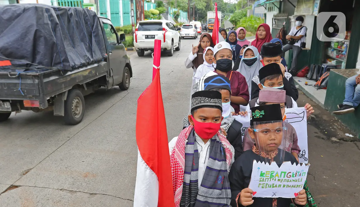 Sejumlah anak pengajian melakukan pawai di Jalan Raya Tapos, Depok, Jawa Barat, Kamis (22/10/2020). Pengajian Kampung Tapos menggelar pawai menyambut Hari Santri Nasional 2020 yang diperingati setiap tanggal 22 Oktober. (Liputan6.com/Herman Zakharia)