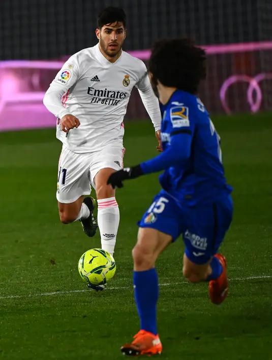 Gelandang Real Madrid, Marco Asensio menggiring bola dari kawalan bek Getafe, Marc Cucurella pada pertandingan lanjutan La Liga Spanyol di stadion Alfredo di Stefano di Madrid, Spanyol, Rabu (10/2/2021). Madrid menang atas Getafe 2-0. (AFP/Gabriel Bouys)