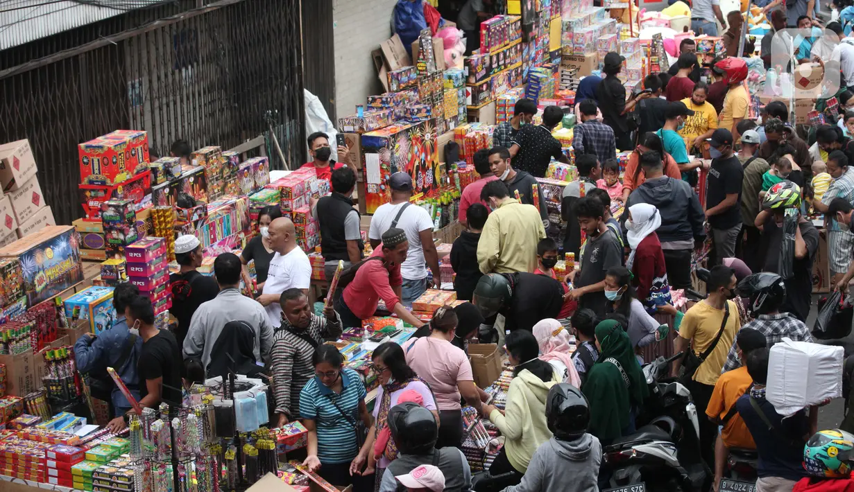 Orang-orang memadati sejumlah pedagang kembang api di Pasar Asemka, Jakarta, Kamis (30/12/2021). Meski Larangan Tahun Baru 2022 diberlakukan untuk membatasi mobilitas, namun masih banyak warga yang berburu kembang api baik untuk dijual maupun digunakan sendiri. (Liputan6.com/Johan Tallo)