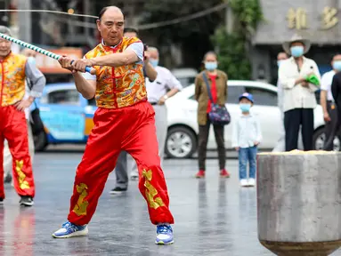 Seorang anggota Klub Gasing Kylin Guiyang memainkan sebuah gasing raksasa di Lapangan Jiaxiulou di Guiyang, Provinsi Guizhou, China barat daya, (15/5/2020). Sekitar 38 anggota klub tersebut menampilkan atraksi memainkan gasing seberat 243,08 kilogram di Guiyang pada Jumat (15/5). (Xinhua/Ou Dongqu)