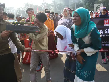 Masyarakat Relawan Indonesia melakukan aksi teatrikal untuk muslim rohingya di Bundaran HI, Jakarta, Minggu (3/9). Aksi solidaritas tersebut mengecam kekerasan yang terjadi pada muslim Rohingya yang di lakukan militer Myanmar. (Liputan6.com/Angga Yuniar)