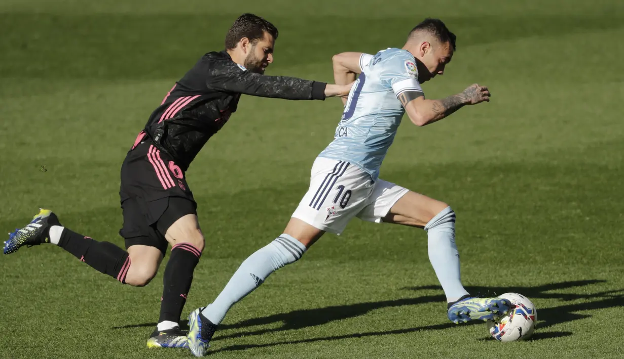 Penyerang Celta Vigo, Iago Aspas dikejar oleh bek Real Madrid, Nacho pada lanjutan Liga Spanyol 2020/2021 di Balaidos, Sabtu (20/3/2021). Karim Benzema jadi bintang saat Real Madrid melibas Celta Vigo 3-1. (AP Photo/Lalo R.Villar)