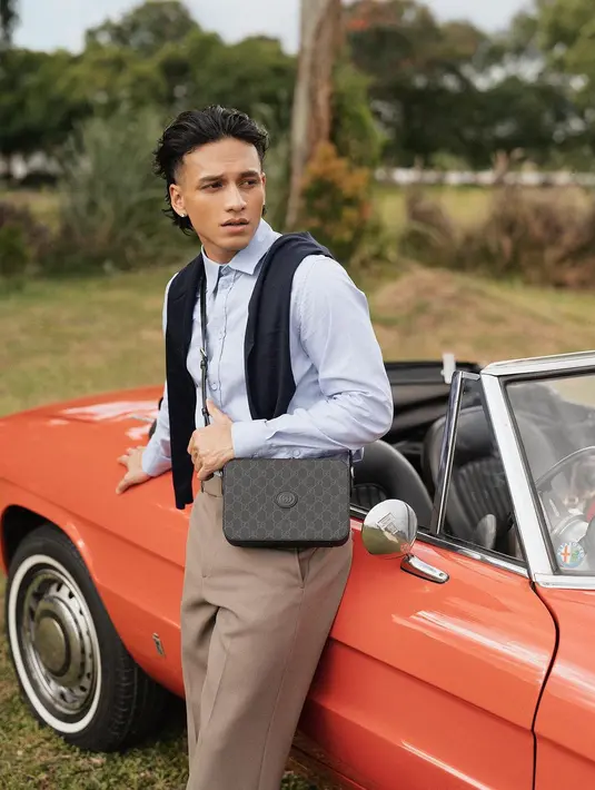 Pesona Jefri Nichol dibalut outfit all Gucci. Kemeja biru polos dipadu celana panjang cokelat, Jefri menyampirkan sweater biru navy dan sling bag Gucci hitam. [Foto: Instagram/winstongomez]