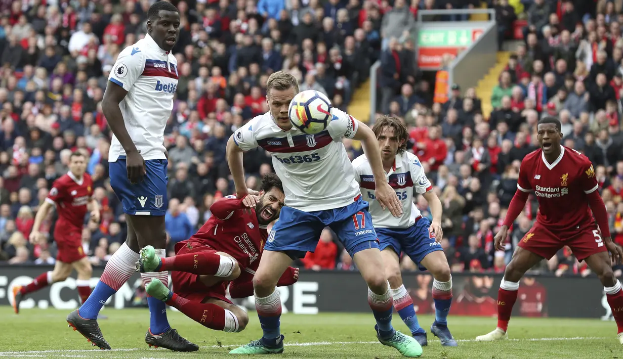 Pemain Liverpool, Mohamed Salah jatuh saat berebut bola dengan pemain Stoke city pada lanjutan Premier League di Anfield, Liverpool, (28/4/2018). Liverpool hanya bermain imbang 0-0 melawan Stoke City. (Martin Rickett/PA via AP)