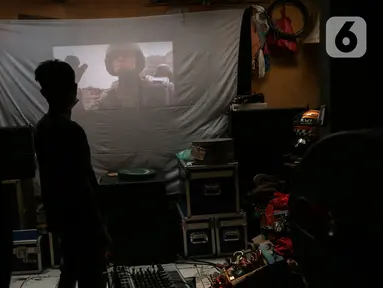 Adul (29) mengecek video di sebuah layar di gudang rumahnya di Jakarta, Rabu (28/4/2021). Sebelum masa pandemi, industri layar tancap memang perlahan mulai redup. (Liputan6.com/Johan Tallo)