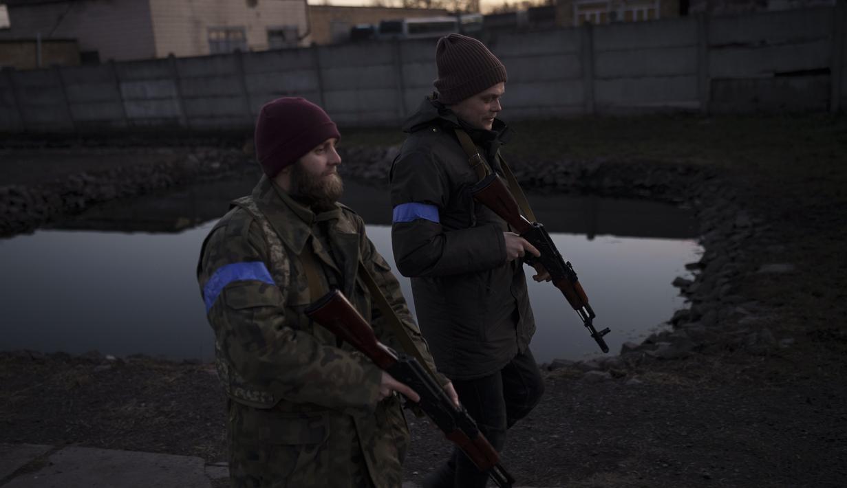Relawan sipil membawa senapan yang diturunkan saat menghadiri kamp pelatihan Pasukan Pertahanan Teritorial Ukraina di Brovary, timur laut Kiev, Ukraina, Senin (21/3/2022). (AP Photo/Felipe Dana)
