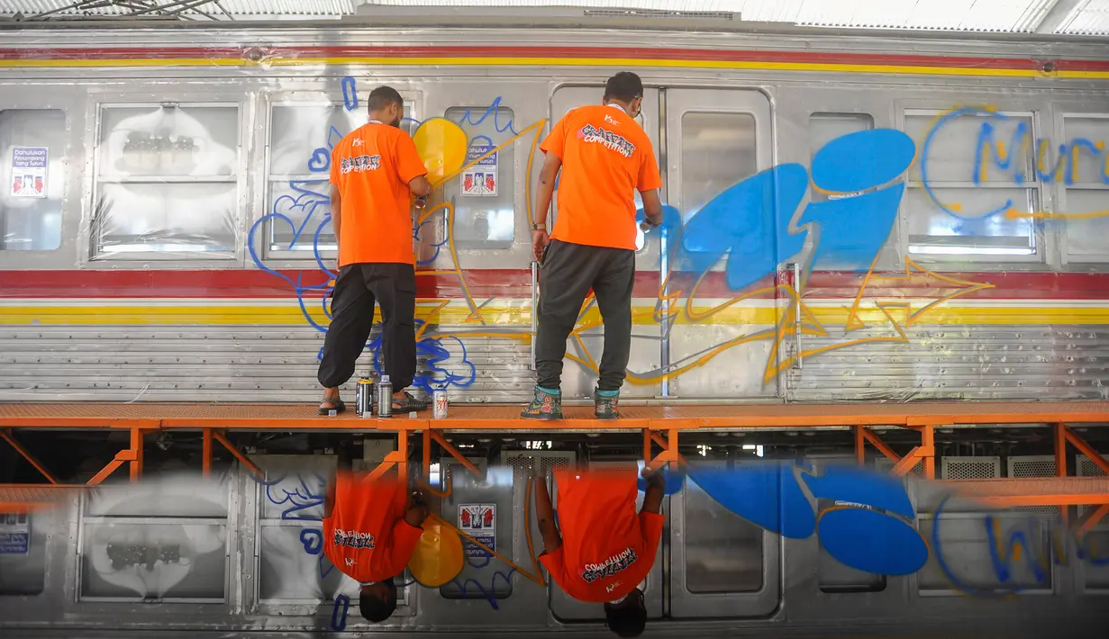 Seniman mural dan grafiti menggambar pada gerbong Kereta Rangkaian Listrik (KRL) Edukasi di Depo KRL, Depok, Jawa Barat, Kamis (29/8/2024). (merdeka.com/Arie Basuki)