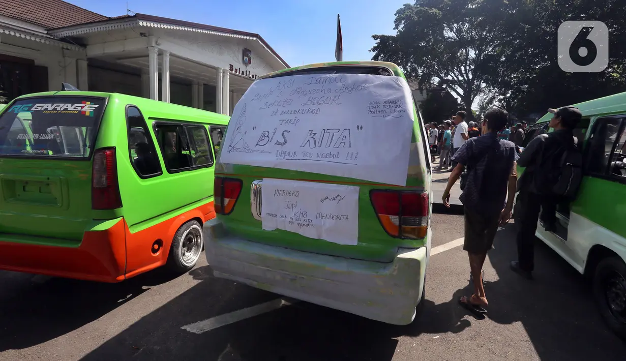 Para sopir menempeli angkot mereka dengan kertas bertuliskan tuntutan saat melakukan unjuk rasa di Balai Kota Bogor. (merdeka.com/Arie Basuki)