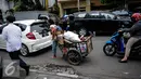 Ditengah kemacetan Jakarta seorang ibu membawa dua orang anaknya bersama dengan gerobak yang berisi barang bekas, mengitari jalan mengumpulkan barang bekas yang di bisa dijual, Jakarta, Kamis (6/10). (Liputan6.com/Faizal Fanani)