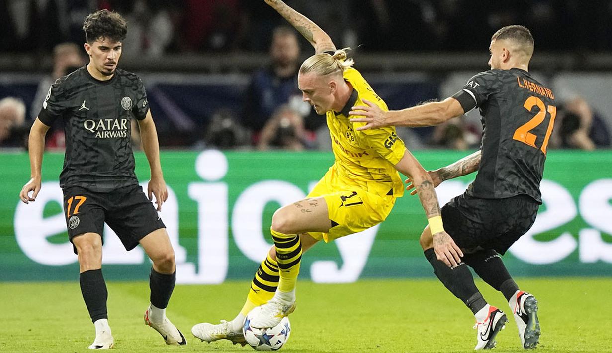 Pemain Paris Saint-Germain (PSG), Lucas Hernandez, menjaga ketat pemain Borussia Dortmund, Marius Wolf, pada laga Liga Champions di Stadion Parc des Princes, Rabu (20/9/2023). Bermain di kandang sendiri, PSG tampak percaya diri dan bermain efektif meladeni Dortmund. (AP Photo/Michel Euler)