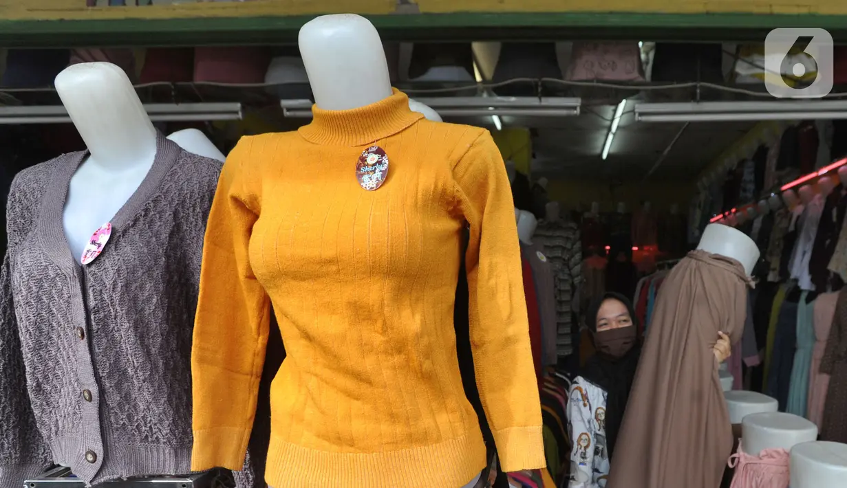 Warga membenahi  display  busana pada sebuah toko di sentra konveksi Bulak Timur, Depok, senin (11/5/2020). Jelang Lebaran 2020, pembuat dan penjual konveksi di kawasan ini mengeluhkan anjloknya penjualan hingga 80% hingga 90% akibat dampak pandemi Covid-19. (merdeka.com/Arie Basuki)