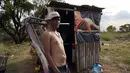 Seorang warga menjaga gubuknya selama kebakaran semak di lingkungan Banco San Miguel di Asuncion, Paraguay (18/1/2022). Cuaca kering yang tidak biasa memicu kebakaran di lapangan terbuka, peternakan pribadi, dan lahan publik sekitar kota. (AP Photo/Jorge Saenz)