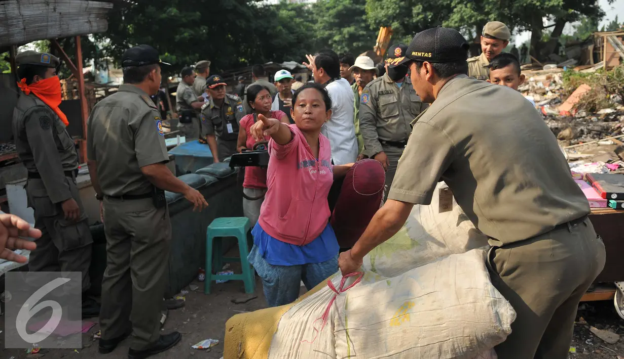 Warga dibantu petugas mengevakuasi barang saat penggusuran di kawasan TPU Menteng Pulo, Jakarta Selatan (7/4). Lebih dari seratus kepala keluarga digusur karena menempati lahan dan mendirikan bangunan di pemakaman umum. (Liputan6.com/Gempur M Surya)