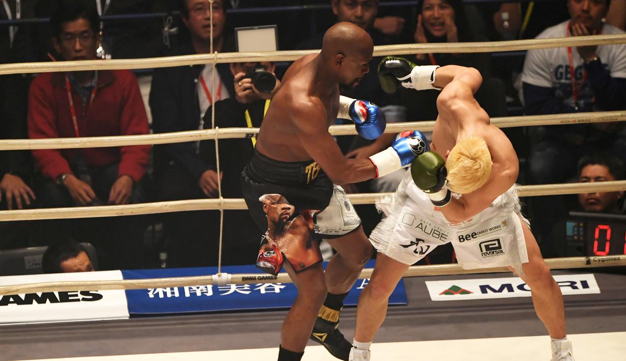 Petinju, Floyd Mayweather, beradu pukulan dengan kickboxer, Tenshin Nasukawa, pada laga eksebisi di Saitama Super Arena, Saitama, Senin (31/1). Tanding dengan aturan tinju, Mayweather menang TKO di ronde pertama. (AFP/Toshifumi Kitamura)