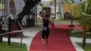 Peserta menyiram air saat berlari selama Rhino Cross Triathlon 2018 di Kawasan Tanjung Lesung, Pandeglang, Banten, Minggu (30/9). Rhino Cross Triathlon diikuti lebih dari 200 peserta dari dalam negeri dan manca negara. (Liputan6.com/HO/Nick Hanoatubun)