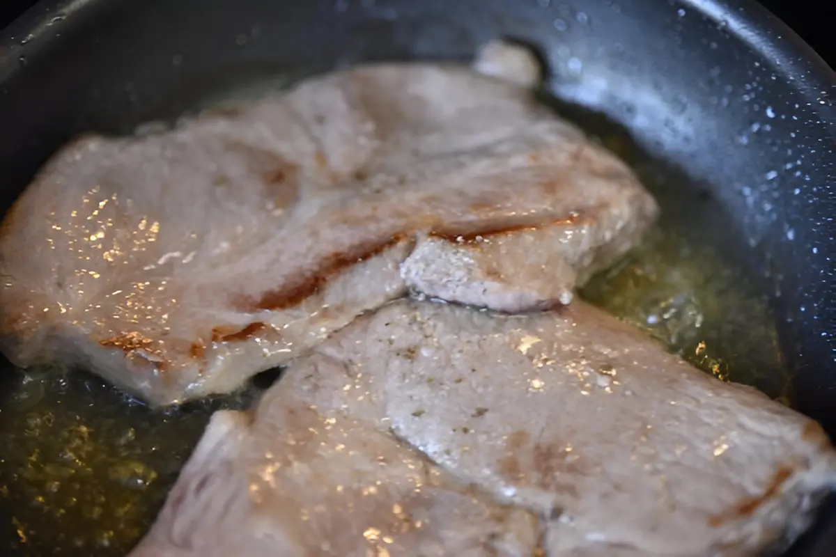 Dua potong daging sedang dimasak hingga minyaknya keluar di sebuah panci (Foto Dok: Freepik/EyeEm)