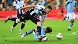 Bek Lazio, Stefan Radu, berebut bola dengan penyerang Udinese, Kevin Lasagna, pada laga lanjutan Serie A pekan ke-33 di Dacia Arena, Kamis (16/7/2020) dini hari WIB. Lazio bermain imbang 0-0 atas Udinese. (AFP/Miguel Medina)