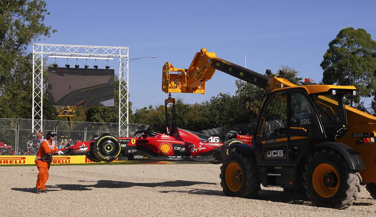 Petugas mengeluarkan mobil milik pembalap Scuderia Ferrari, Charles Leclerc dari gravel setelah terjadi senggolan dengan Lance Stroll di tikungan 3 dalam balapan Formula 1 GP Australia di Sirkuit Albert Park, Melbourne, pada Minggu (2/4/2023). (AP Photo/Scott Barbour)
