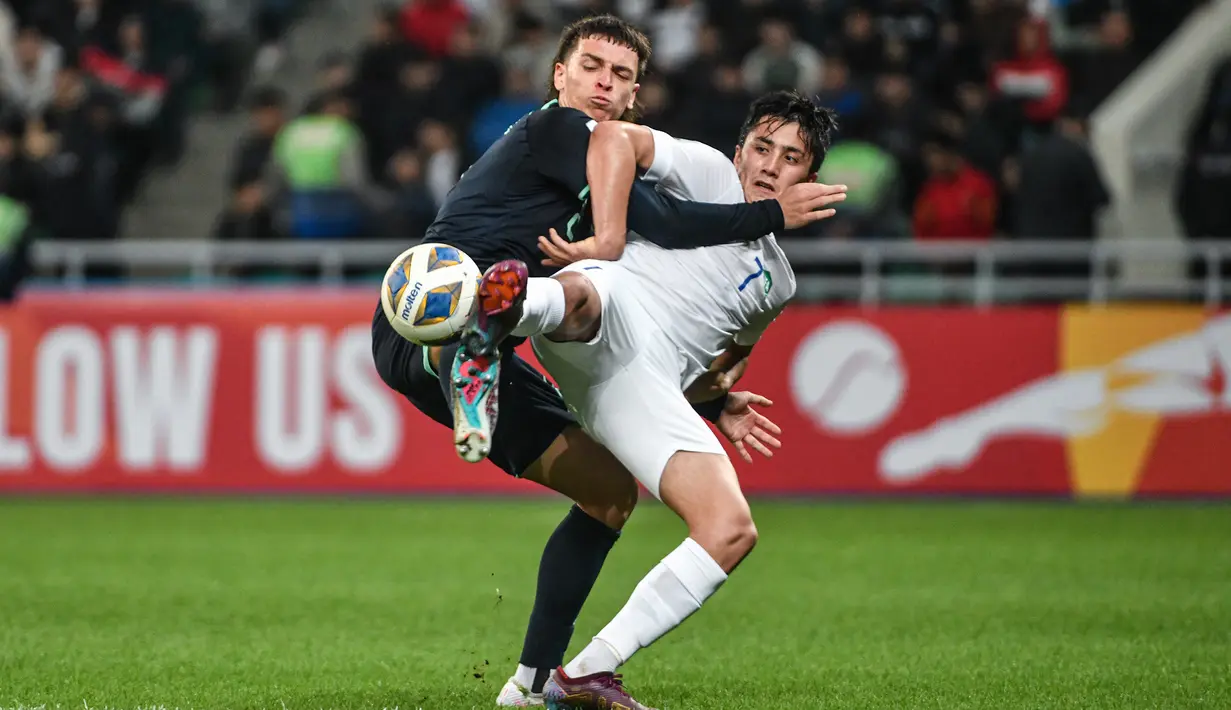 Pemain Uzbekistan U-20, Pulatkhuja Kholdorkhonov (kanan) berebut bola dengan pemain Australia U-20, Joshua Rawlins pada laga perempatfinal Piala Asia U-20 2023 di Milliy Stadium, Tashkent, Uzbekistan, Sabtu (11/3/2023). (AFC/Hasan Pirmuhamedov)