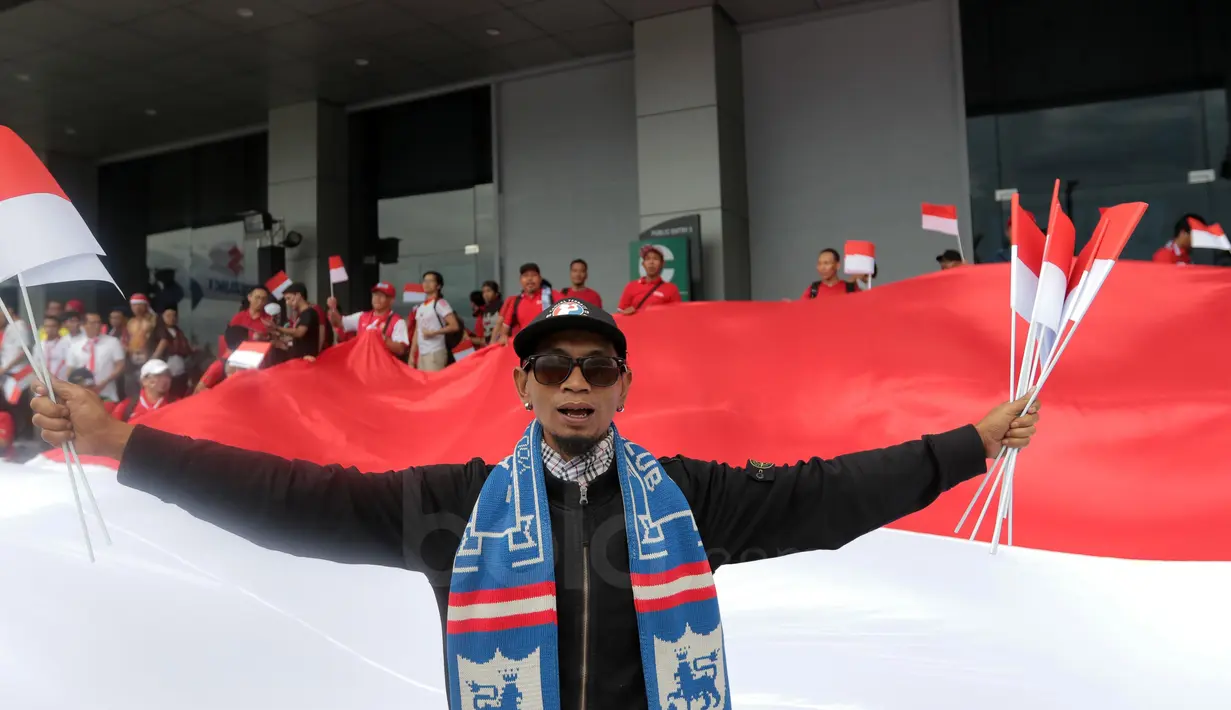 Aksi Suporter Arema berbaur membentangkan bendera Merah-Putih saat memberi dukungan untuk Timnas Indonesia melawan Thailand pada laga AFF Suzuki Cup 2016 di Philippine Sports Stadium, (19/11/2016).  (Bola.com/Nicklas Hanoatubun)