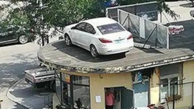 Sebuah mobil terlihat parkir di atap pos security.