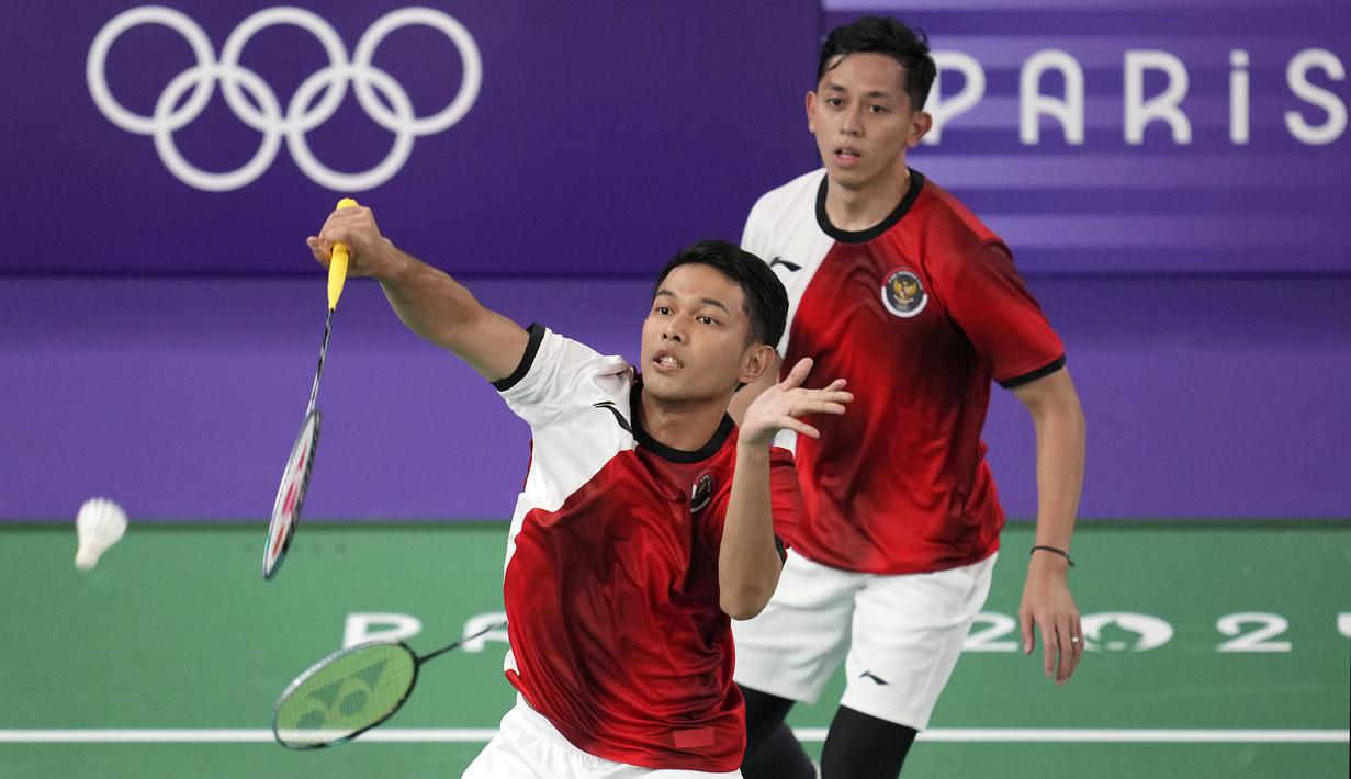 Pebulu tangkis ganda putra Indonesia, Fajar Alfian/Rian Ardianto berfoto berusaha mengembalikan kok ke arah pasangan Jerman, Mark Lamsfuss/Marvin Seidel pada Grup C cabang olahraga bulu tangkis Olimpiade Paris 2024 di Porte de la Chapelle Arena, Paris, Pancis, Sabtu (27/07/2024). (AP Photo/Kin Cheung)