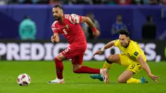 Pemain Yordania Yazan Alarab (kiri) mengincar bola saat pemain Malaysia Darren Lok terjatuh pada pertandingan sepak bola Grup E Piala Asia di Stadion Al Janoub, Al Wakrah, Qatar, Senin (15/1/2024). (AP Photo/Aijaz Rahi)