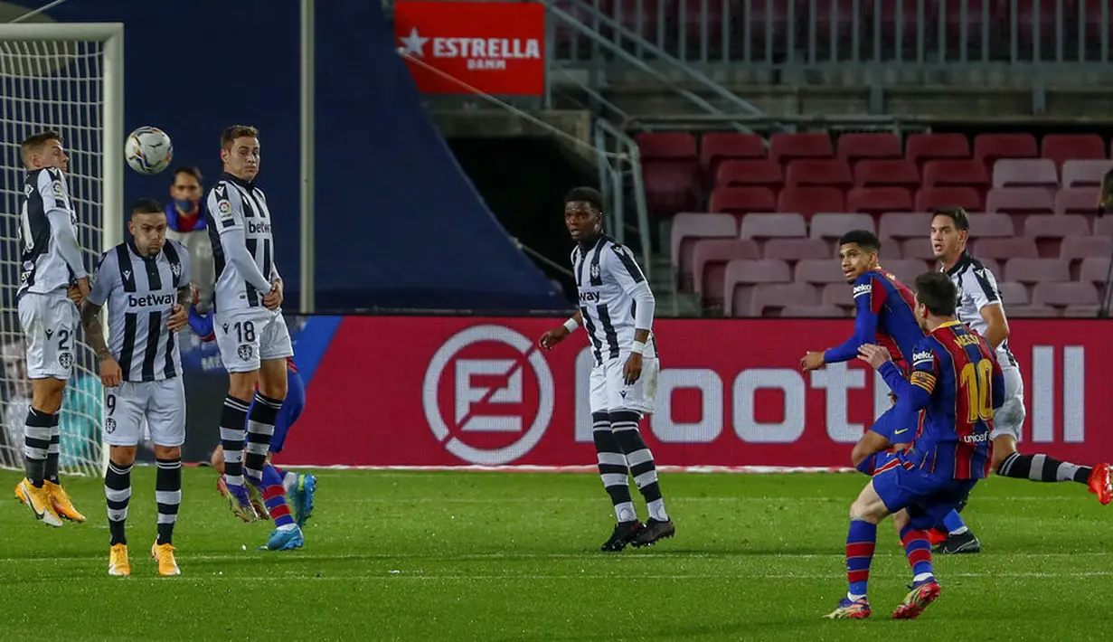 Pemain Barcelona Lionel Messi (kanan) melakukan tendangan bebas saat melawan Levante pada pertandingan La Liga Spanyol di Stadion Camp Nou, Barcelona, Spanyol, Minggu (13/12/2020). Barcelona menang 1-0. (AP Photo/Joan Monfort)