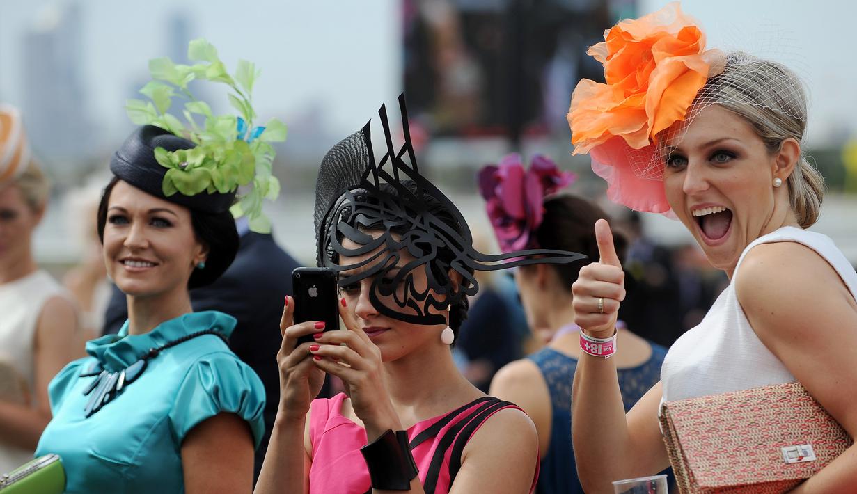 Sekumpulan wanita berfoto bersama saat menghadiri balap kuda Melbourne di arena pacuan kuda Flemington Racecourse di Melbourne, Australia (1/11). Acara ini berlangsung dari September hingga pertengahan November. (AFP/Paul Crock)