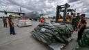 Personel TNI Angkatan Udara dan petugas Badan Nasional Penanggulangan Bencana (BNPB) bersiap memasukkan bantuan kemanusiaan dari pemerintah Indonesia untuk korban gempa bumi di Myanmar ke dalam pesawat angkut Hercules C-130 di Pangkalan Udara Halim Perdanakusuma, Jakarta, 31 Maret 2025. (BAY ISMOYO/AFP)