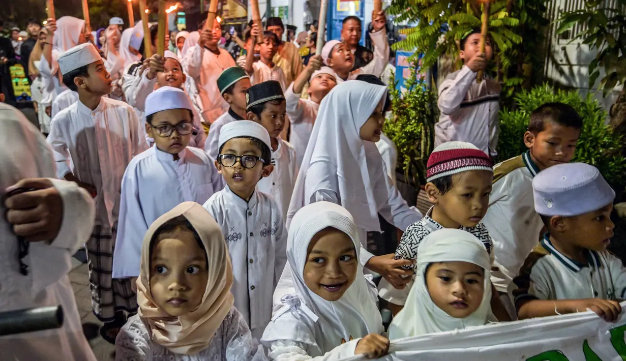 Bertepatan dengan malam Tahun Baru Islam 1 Muharram 1447 Hijriah, masyarakat kota Surabaya, Jawa Timur melakukan tradisi pawai obor di salah satu permukiman pada Kamis 26 Juni 2025 malam. (Juni KRISWANTO/AFP)